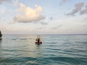 A serene view of a boat anchored in calm waters, surrounded by a picturesque sky — perfect for showcasing the beauty of boating adventures.