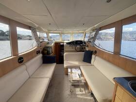 A spacious and well-designed interior of a boat featuring comfortable seating and a helm area, perfect for relaxing while enjoying scenic views.