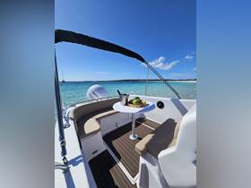 A stylish interior view of a boat's seating area featuring a dining table with fresh fruits and a drink, perfect for enjoying meals while cruising on the water.