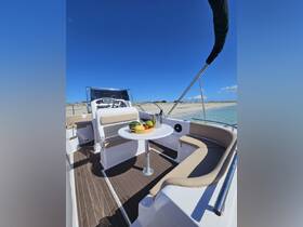 A stylish interior view of a boat's dining area featuring comfortable seating and a table adorned with fresh fruits, perfect for relaxing on the water.