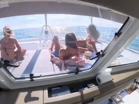 A group of friends relaxes on the deck of a boat, enjoying the sun and ocean views — the perfect setting for a day of leisure on the water.