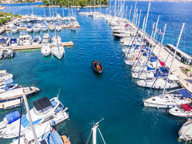 Aerial view of a marina filled with various boats, showcasing a vibrant scene of docked vessels in clear blue waters.