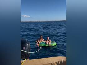 A couple enjoys tubing in the open water, showcasing the thrill of on-water activities and summer fun.
