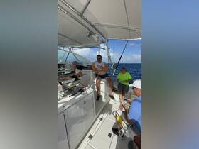 A lively group enjoys a fishing trip aboard a boat, sharing food and good times while surrounded by the ocean — a perfect day on the water.