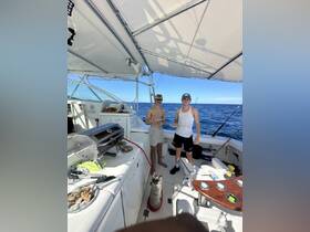 Two friends enjoy a day of fishing on a boat, grilling delicious food while surrounded by the open sea — perfect for a fun day on the water.