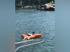 A man enjoys a sunny day floating on a fun inflatable in the water, capturing the essence of summer relaxation and outdoor fun.