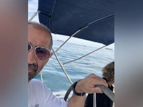 A person steers a boat while enjoying a sunny day on the water, capturing the essence of a sailing adventure.