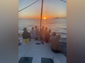 A group of friends enjoys a stunning sunset aboard a yacht, creating unforgettable memories on the water.