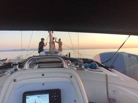 A group of friends enjoys a beautiful sunset while sailing, creating a memorable experience on the water.