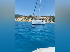 A beautiful sailboat glides through crystal-clear waters, showcasing the stunning coastal scenery in the background — perfect for sailing enthusiasts.