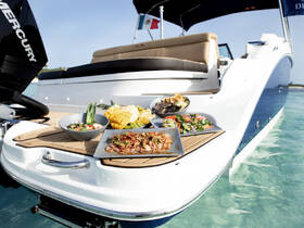 A beautifully arranged spread of delicious food on the deck of a boat, perfect for enjoying a gourmet meal while cruising on the water.
