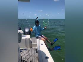 A young man prepares for a snorkeling adventure, showcasing his gear and excitement aboard a boat — perfect for water sports enthusiasts.