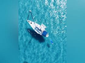 A stunning aerial view of a sailboat gliding through crystal-clear turquoise waters, showcasing the beauty of sailing adventures.