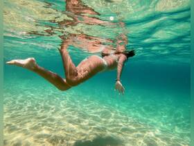A swimmer glides gracefully through crystal-clear waters, showcasing the beauty of underwater exploration — a perfect scene for snorkeling or diving adventures.