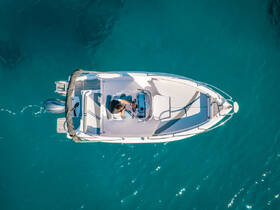 Aerial view of a person navigating a sleek boat through crystal-clear waters, showcasing the beauty of a day on the water.