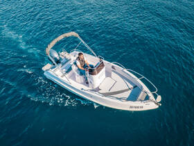 A man navigates a sleek speedboat through vibrant blue waters, showcasing the thrill of boating adventures.