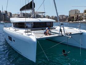 A lively scene aboard a Lagoon catamaran, featuring a man interacting with a child swimming nearby — perfect for family adventures on the water.