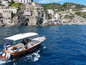 A group enjoys a scenic boat tour along the stunning Amalfi Coast, capturing the beauty of the coastline and vibrant architecture.