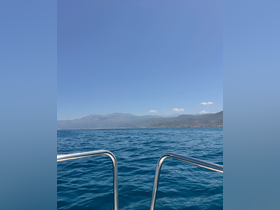 A stunning view of the coastline and mountains from a boat, showcasing the beauty of the ocean and the surrounding landscape.