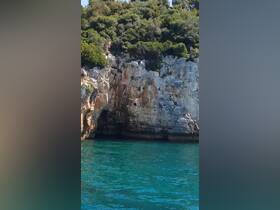 Adventurous individuals enjoy cliff diving into crystal-clear waters, showcasing the thrill of summer activities in a stunning natural setting.