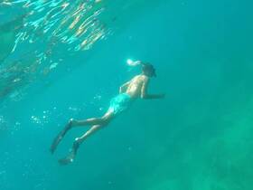 A young snorkeler explores the vibrant underwater world, showcasing the beauty of marine life in crystal-clear waters.