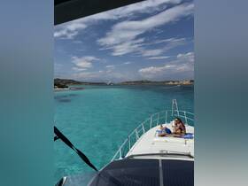 A couple enjoys sunbathing on the deck of a boat, surrounded by stunning turquoise waters and picturesque island scenery — a perfect getaway for relaxation and adventure.
