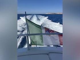 A stunning view of a boat's wake as it cruises through deep blue waters, showcasing the vibrant flag flying proudly at the bow.