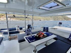 A beautifully arranged interior of a yacht featuring a comfortable lounge area with floral decor, perfect for relaxing while enjoying the scenic views of the water.