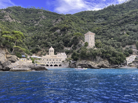 A stunning view of a coastal landmark surrounded by lush greenery, showcasing the beauty of the Italian coastline — perfect for sightseeing and exploration.