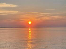 A stunning sunset over calm waters, creating a picturesque backdrop for evening boat cruises or romantic getaways.