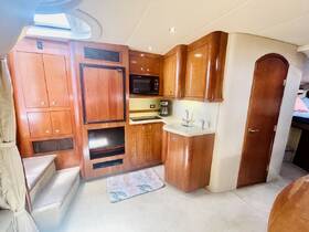 A well-appointed boat interior featuring a cozy kitchen area with wooden cabinetry and modern appliances, perfect for preparing meals while on the water.