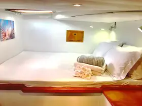 Cozy cabin interior featuring a comfortable bed with fresh linens and towels, perfect for relaxing on a boat getaway.
