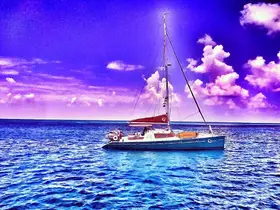 A stunning sailboat glides through vibrant blue waters under a colorful sky, showcasing the beauty of sailing adventures.