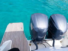 Close-up view of twin Yamaha 300 outboard motors on a boat, showcasing essential marine equipment against a backdrop of clear turquoise waters.