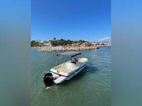 A sleek speedboat is seen cruising near a dock, showcasing its stylish design against a clear blue sky — perfect for day trips and water adventures.