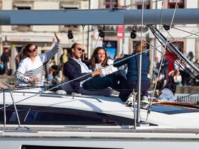 A lively group enjoys drinks and laughter aboard a yacht, capturing the essence of a fun day on the water.
