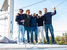 A group of friends celebrates aboard a yacht, raising their glasses in a toast against a beautiful backdrop — perfect for memorable gatherings and celebrations on the water.
