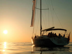 A group enjoys a serene sunset sailing experience aboard a yacht, creating unforgettable memories on the water.
