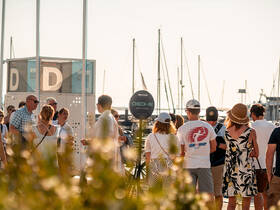 A lively group gathers at the marina for check-in before embarking on their boat tour, showcasing the excitement of a day on the water.