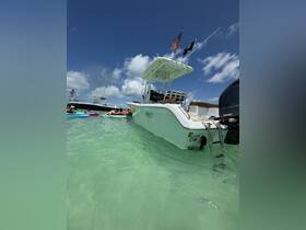 A lively scene at a sandbar with guests enjoying the water around a boat, perfect for summer fun and relaxation.