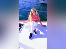 A woman relaxes on the deck of a yacht, enjoying the serene waters — a perfect moment for leisure on the open sea.