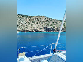 A stunning view from the deck of a catamaran, showcasing clear blue waters and a picturesque coastline — perfect for sailing adventures and island exploration.