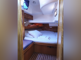 Cozy cabin interior of a boat featuring a comfortable bed and storage space, perfect for relaxing during your nautical adventures.