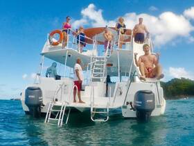 A lively group enjoys a fun day on a boat, featuring a water slide and smiles all around — perfect for summer adventures and celebrations on the water.