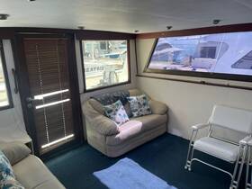 Cozy interior of a boat cabin featuring comfortable seating and large windows, perfect for relaxing while enjoying the views of the marina.