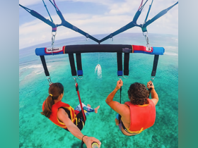 A couple enjoys an exhilarating parasailing adventure over crystal-clear waters, capturing the thrill of ocean activities and stunning aerial views.