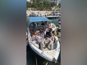 A lively group enjoys their time aboard the boat 'Dhako 1', capturing a fun moment together — perfect for memorable outings on the water.