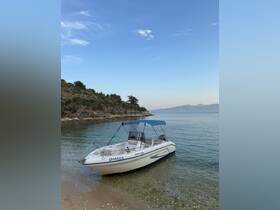 A serene view of the boat 'DHAKO1' docked on a tranquil beach, surrounded by clear waters and lush greenery — perfect for a day of relaxation and exploration.