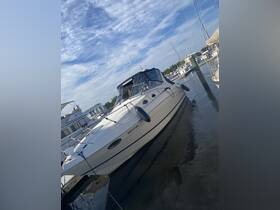A sleek yacht docked at the marina, showcasing its elegant design against a backdrop of clear skies and calm waters.