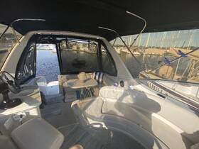 Interior view of a boat cabin featuring comfortable seating and a helm, perfect for relaxing while enjoying the marina views.
